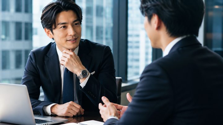 高級腕時計をつけて仕事をしている男性