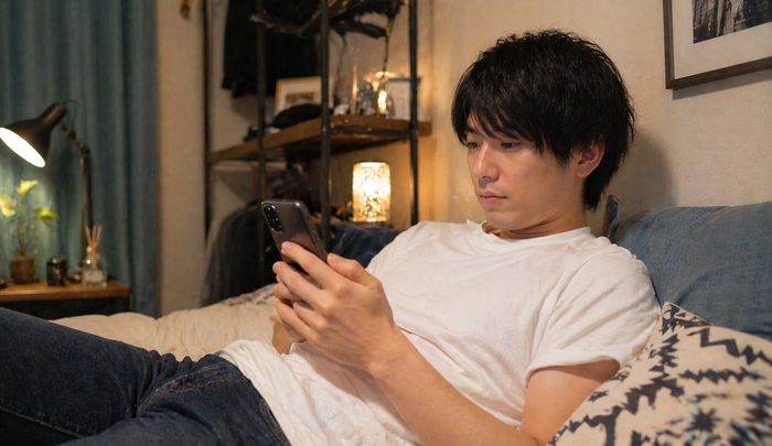 出会い系アプリを操作する男性