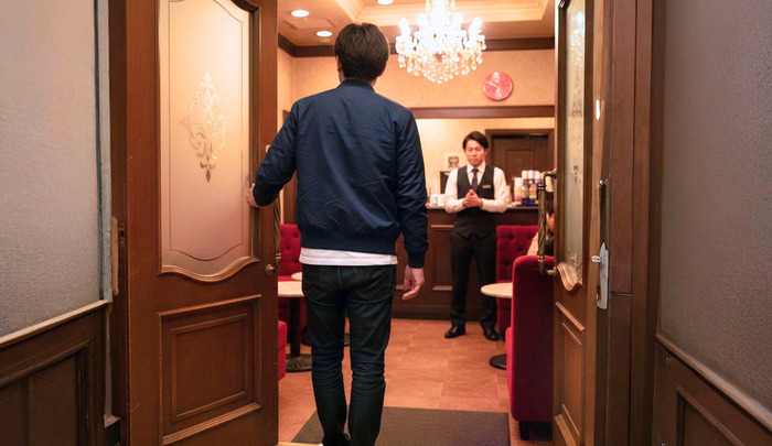 キャバクラ入り口のドアを開けている男性