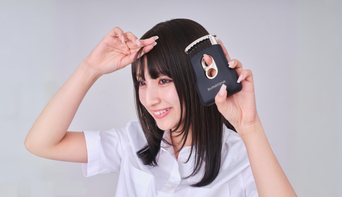 前髪にヘアアイロンする女性