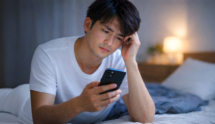 キャバ嬢からの冷めたLINEをみている男性